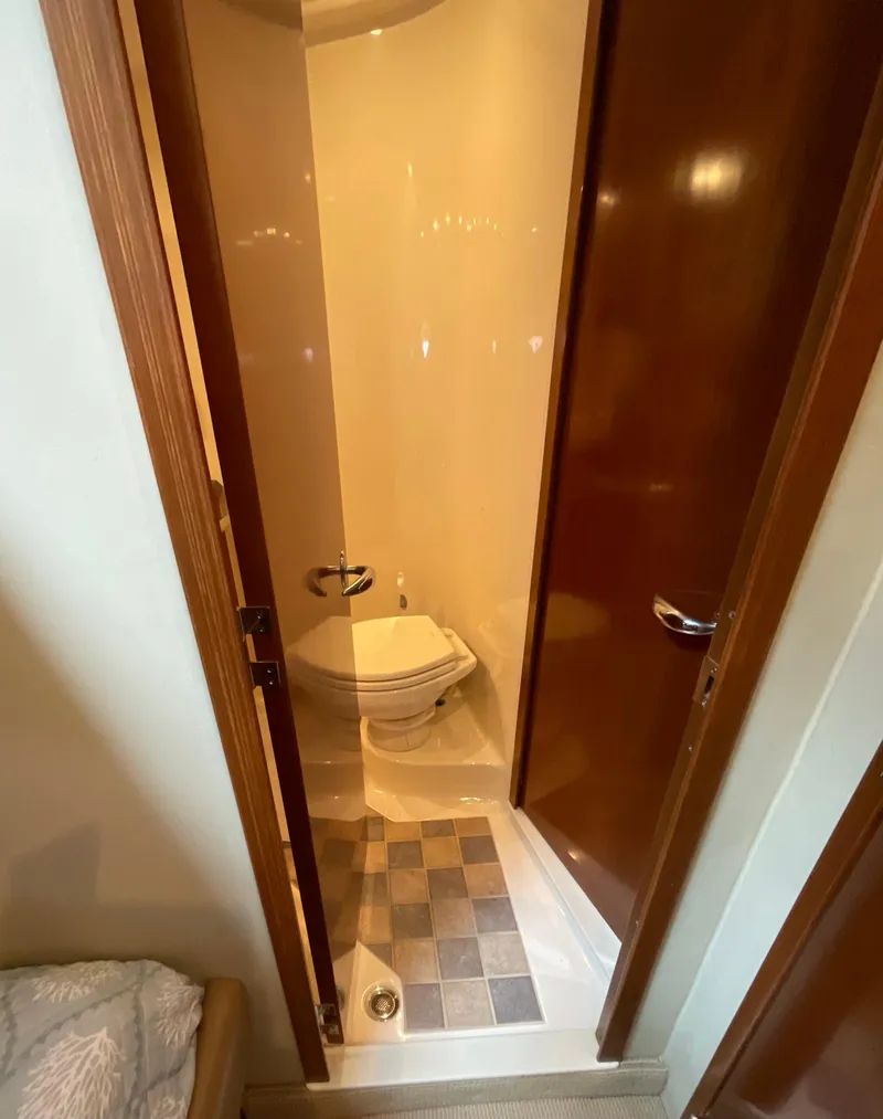 Slide: The Image of Compact bathroom in 2005 Sea Ray 500 Sundancer yacht with wooden door and tiled floor. - 23
