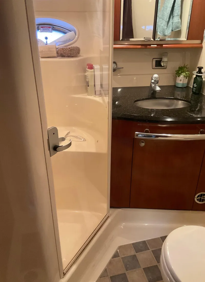 Slide: The Image of Bathroom interior of 2005 Sea Ray 500 Sundancer yacht, featuring shower, sink, and toilet. - 27