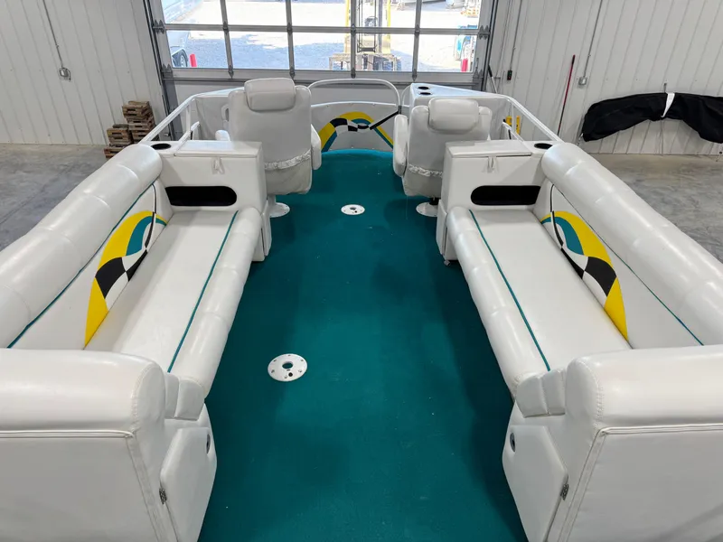 Slide: The Image of 2004 PlayCraft 2800 Powertoon interior with white seating and teal carpet in a garage setting. - 12