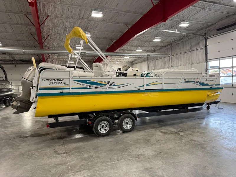 Slide: The Image of 2004 PlayCraft 2800 Powertoon boat with yellow hull in indoor storage. - 3