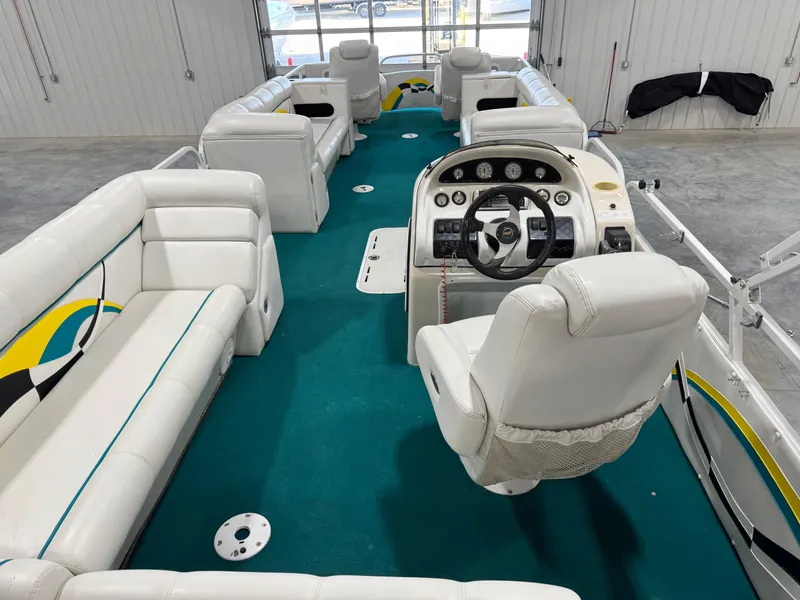 Slide: The Image of 2004 PlayCraft 2800 Powertoon interior with white seating and teal carpet in a garage setting. - 9