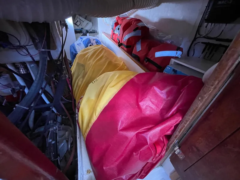 Slide: The Image of Storage area in a 1964 CAL 40 sailboat with colorful bags and life jackets. - 11