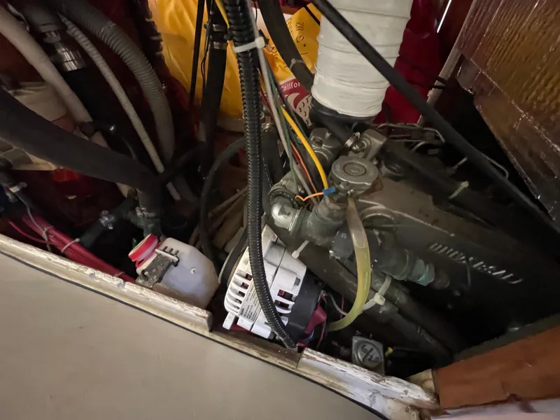Slide: The Image of Engine compartment of a 1964 CAL 40 sailboat, showing various hoses and mechanical components. - 13