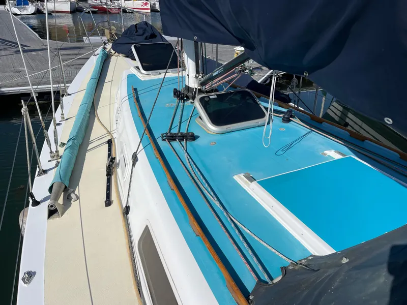 Slide: The Image of 1964 CAL 40 sailboat deck with blue accents, docked at marina. - 2
