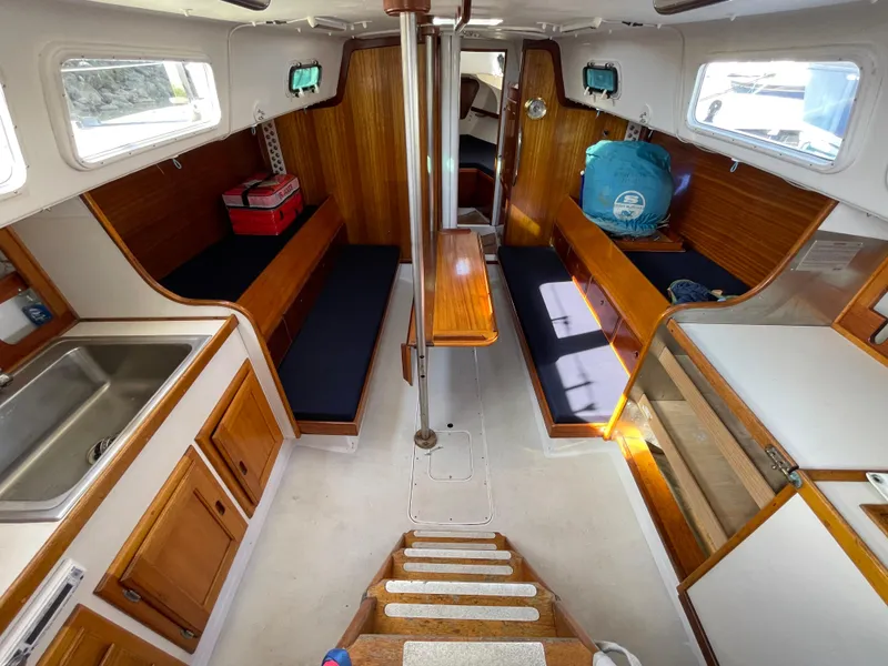 Slide: The Image of Interior of a 1964 CAL 40 sailboat with wooden cabinetry and seating. - 3