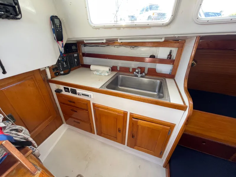 Slide: The Image of 1964 CAL 40 sailboat interior with wooden cabinets and stainless steel sink. - 4