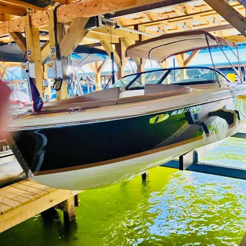 The Image of 2016 Chris-Craft Carina 21 boat docked in a wooden boathouse. - 0