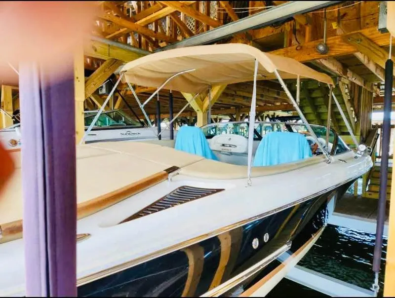 Slide: The Image of 2016 Chris-Craft Carina 21 boat docked under wooden shelter with beige canopy. - 4