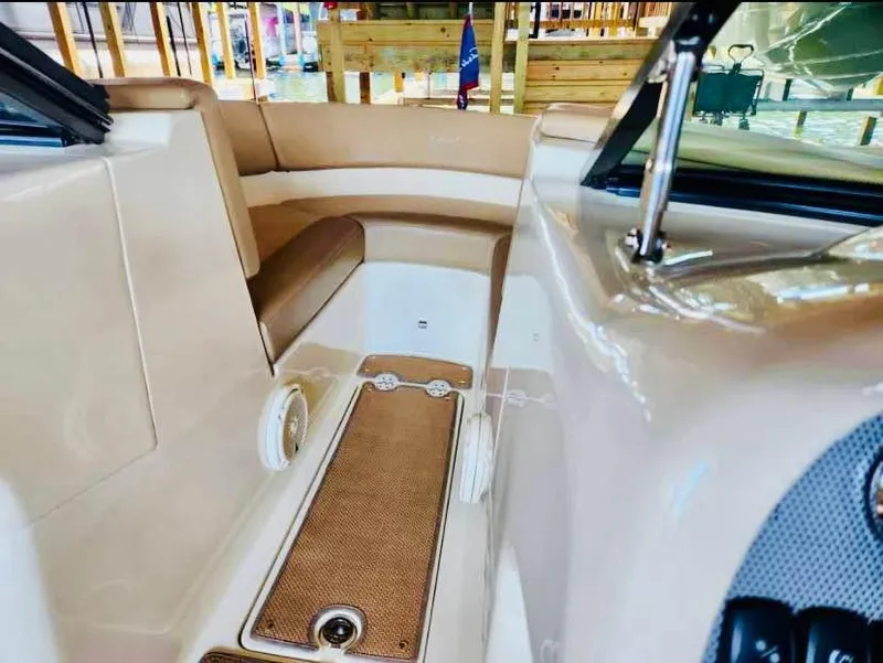 Slide: The Image of 2016 Chris-Craft Carina 21 boat interior with beige seating and wood accents. - 7