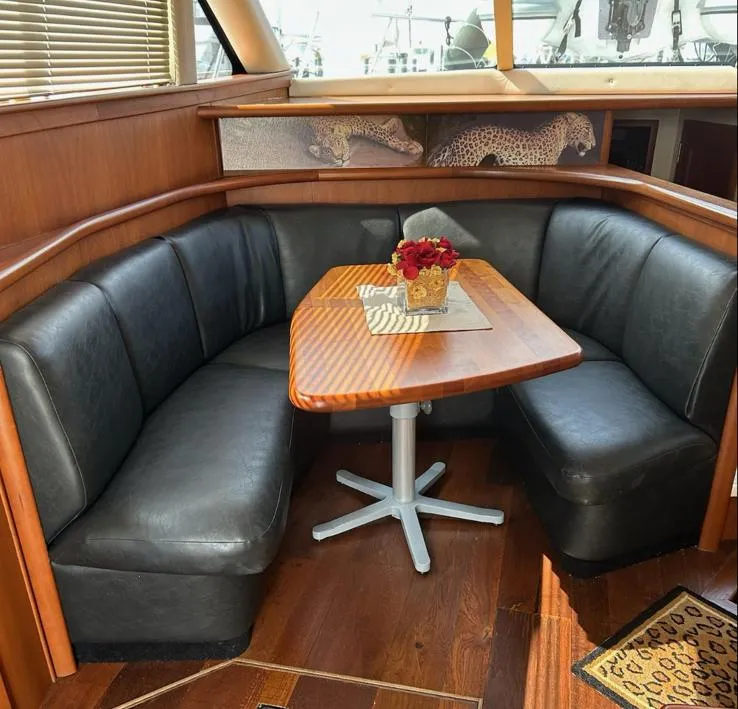 Slide: The Image of Luxurious 2005 Silverton 42 Convertible yacht interior with leather seating and wooden table. - 3