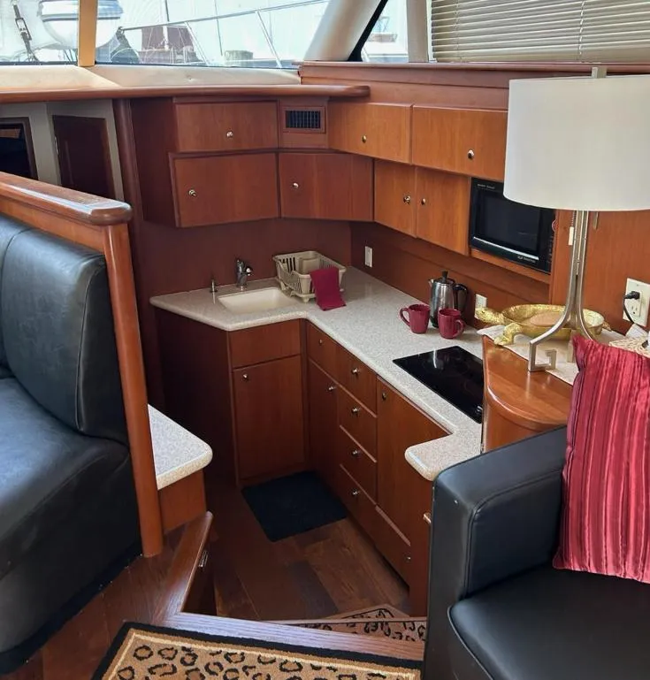 Slide: The Image of Interior of 2005 Silverton 42 Convertible yacht with modern kitchen and seating area. - 5