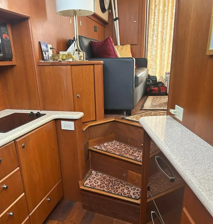 Slide: The Image of Interior of 2005 Silverton 42 Convertible yacht with wooden cabinetry and leopard-print carpeted stairs. - 6