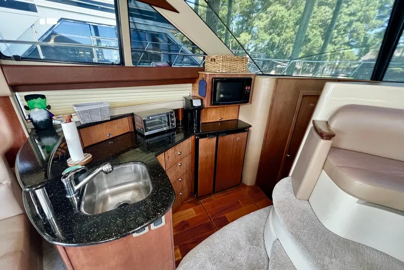 Slide: The Image of 2008 Meridian 391 Sedan yacht interior with kitchenette, featuring sink, microwave, and seating area. - 10
