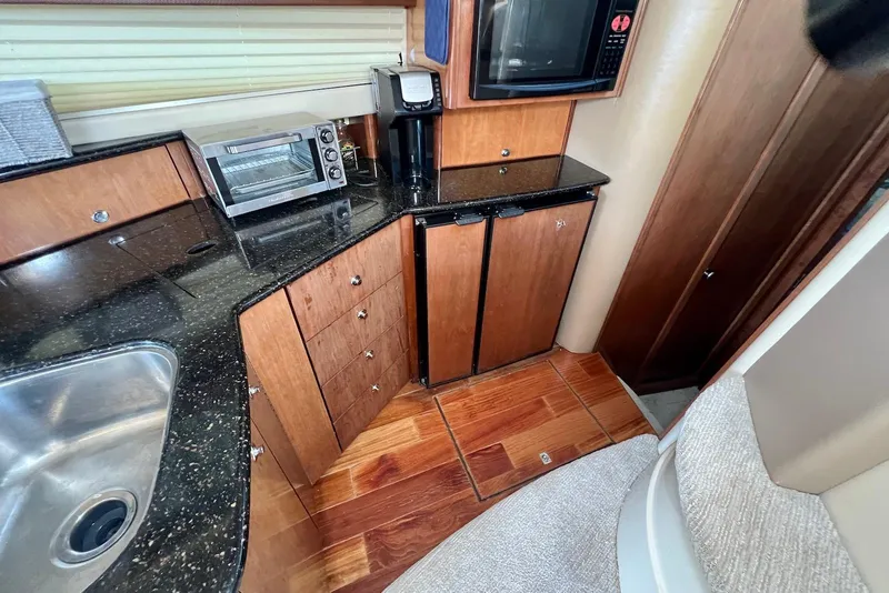 Slide: The Image of 2008 Meridian 391 Sedan yacht kitchen with appliances, wood cabinetry, and black countertops. - 28