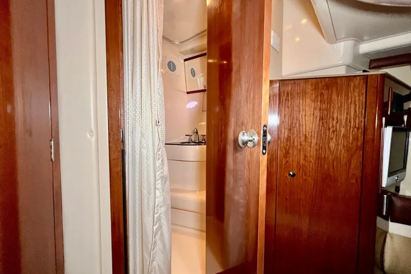 Slide: The Image of Interior of 2008 Meridian 391 Sedan yacht, featuring wooden cabinetry and a compact bathroom. - 29