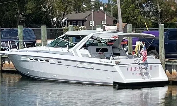 The Image of 1987 Chris-Craft 336 Amerosport boat docked at a marina with American flag. - 0
