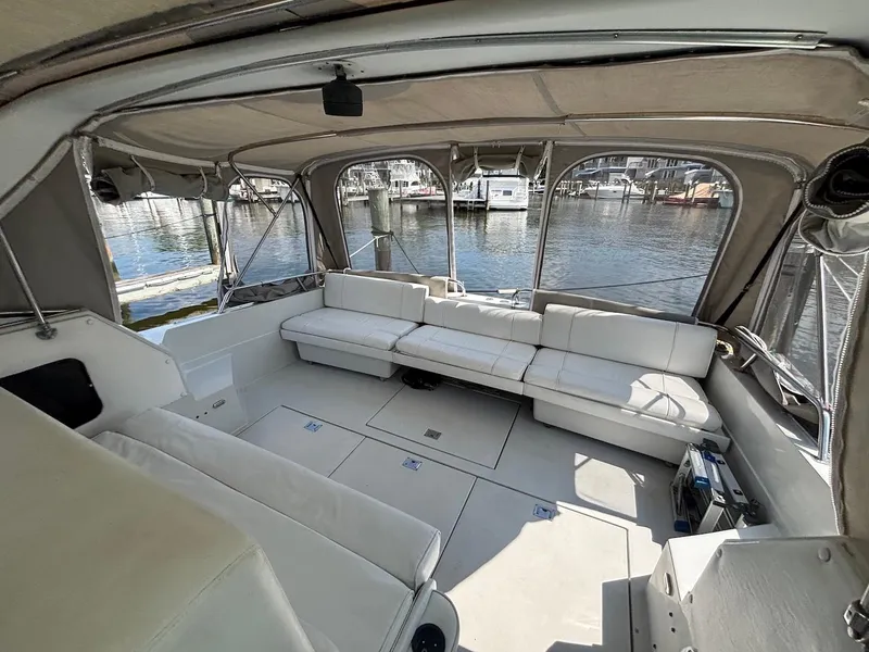 Slide: The Image of 1987 Chris-Craft 336 Amerosport boat interior with white seating and marina view. - 10