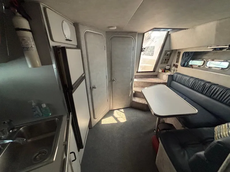 Slide: The Image of Interior of 1987 Chris-Craft 336 Amerosport boat with seating, table, and kitchenette. - 13