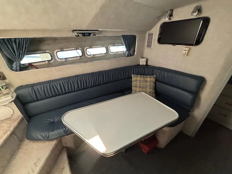 Slide: The Image of 1987 Chris-Craft 336 Amerosport cabin interior with blue seating, table, and windows. - 15
