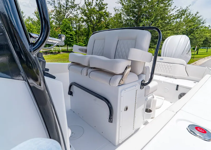 Slide: The Image of 2026 Sea Hunt Ultra 245 SE boat interior with cushioned seating and steering console. - 13
