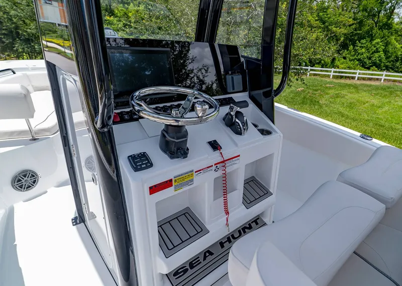 Slide: The Image of 2026 Sea Hunt Ultra 245 SE boat console with steering wheel and controls. - 15
