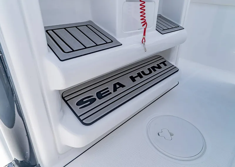 Slide: The Image of 2026 Sea Hunt Ultra 245 SE boat step detail with logo and safety cord. - 20