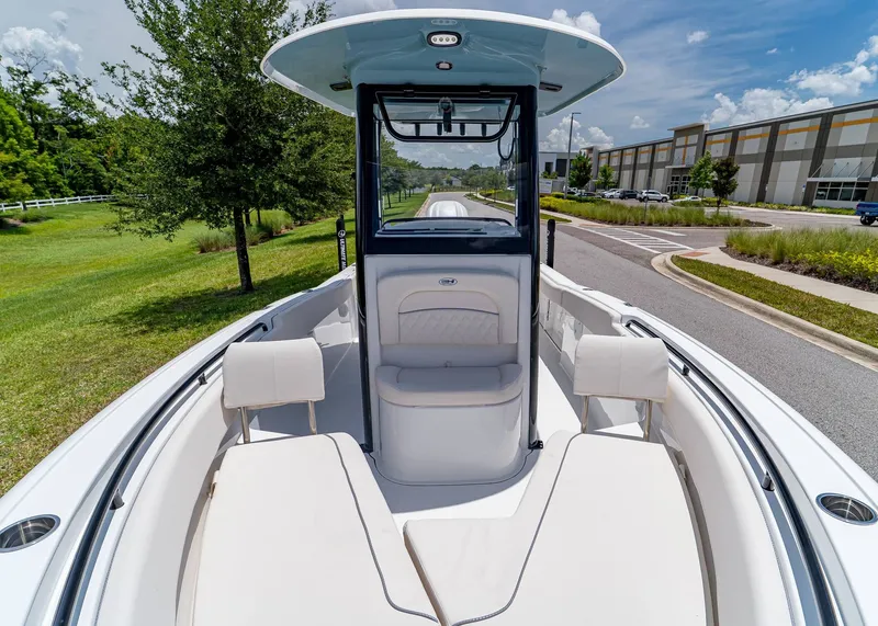 Slide: The Image of 2026 Sea Hunt Ultra 245 SE boat with spacious seating, parked outdoors on a sunny day. - 25