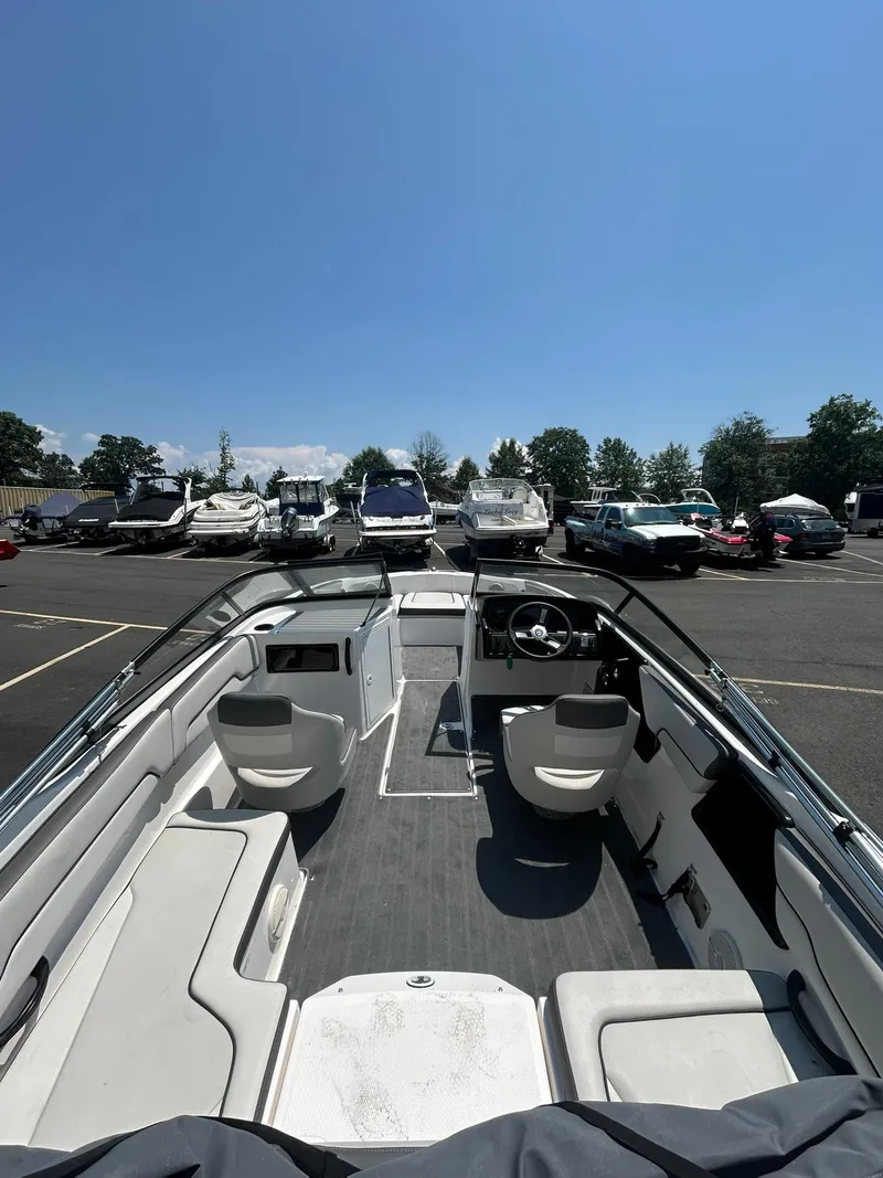 Slide: The Image of 2024 Yamaha Boats SX190 interior view in a parking lot under clear blue sky. - 11