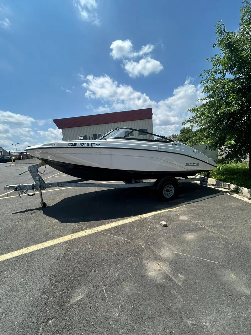 Slide: The Image of 2024 Yamaha Boats SX190 on trailer under clear blue sky. - 3