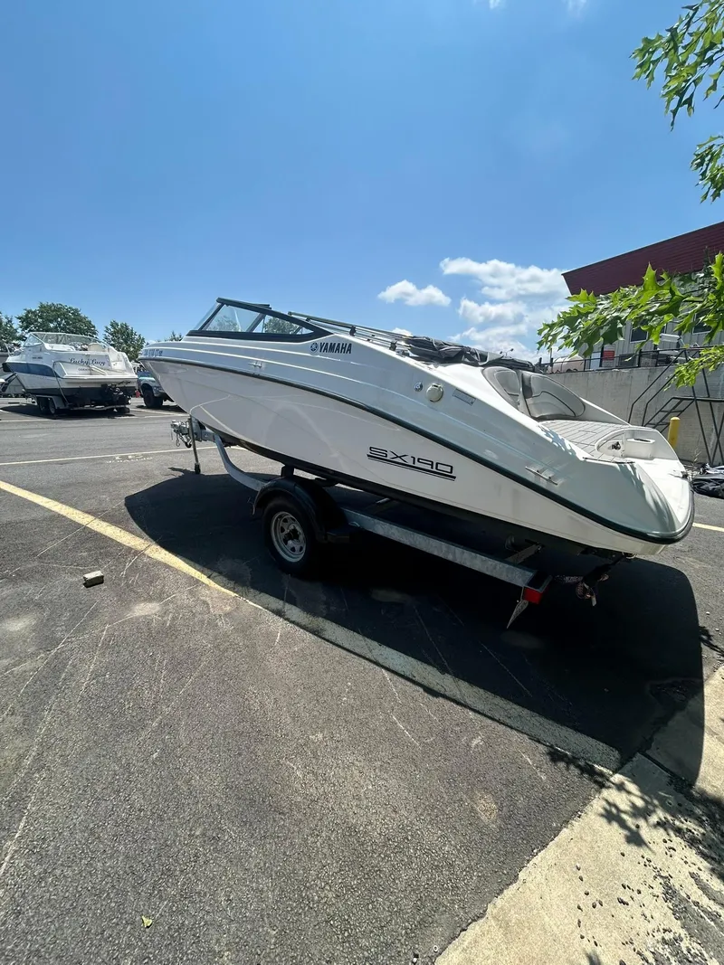 Slide: The Image of 2024 Yamaha SX190 boat on trailer under clear blue sky. - 4