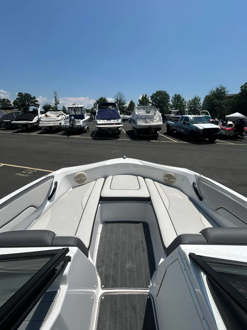 Slide: The Image of 2024 Yamaha Boats SX190 interior view at a marina under clear blue sky. - 5