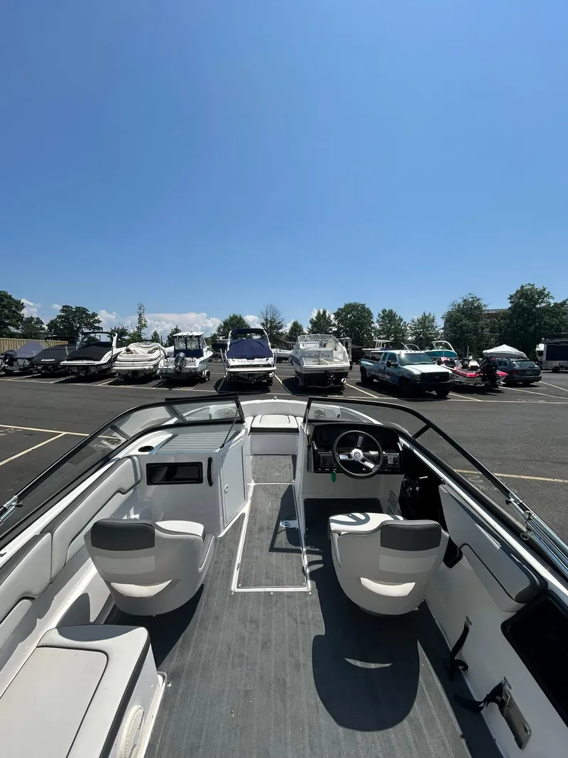 Slide: The Image of 2024 Yamaha Boats SX190 interior view in a sunny parking lot. - 7