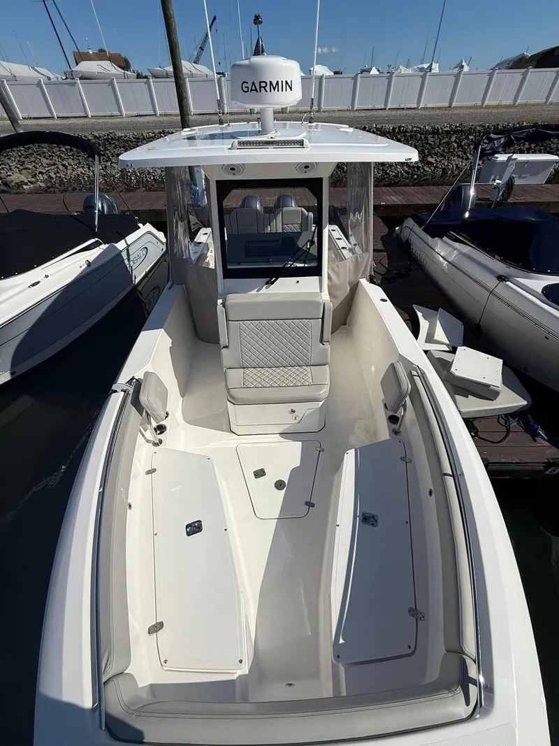 Slide: The Image of 2023 Pursuit S 268 Sport boat docked, featuring spacious deck and Garmin equipment. - 11