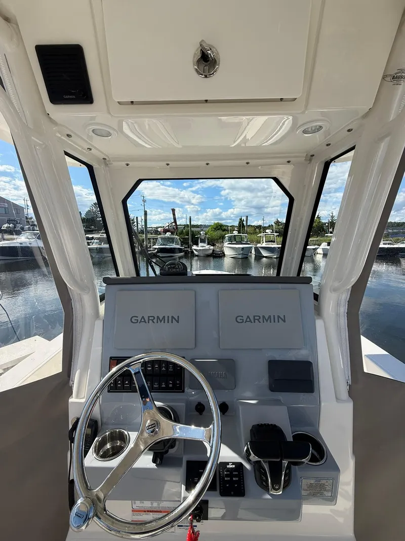 Slide: The Image of 2023 Pursuit S 268 Sport boat helm with dual Garmin displays at marina. - 15