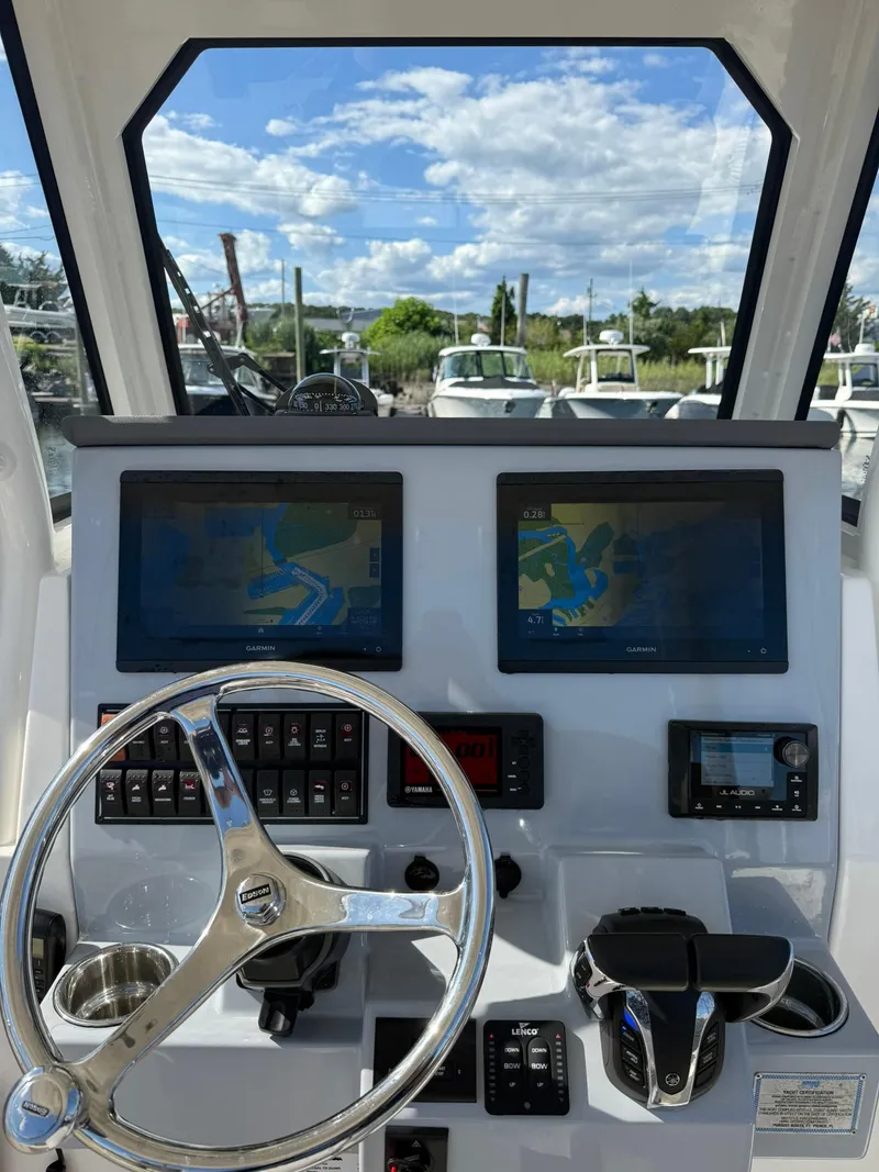 Slide: The Image of 2023 Pursuit S 268 Sport boat dashboard with navigation screens and steering wheel. - 16