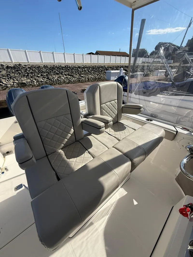 Slide: The Image of 2023 Pursuit S 268 Sport boat interior with cushioned seating and armrests. - 19