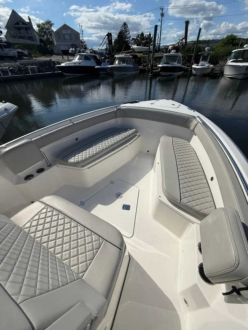 Slide: The Image of 2023 Pursuit S 268 Sport boat with luxurious seating at a marina. - 6