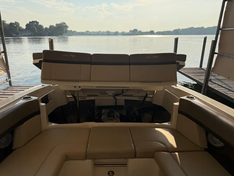 Slide: The Image of 2012 Sea Ray 270 SLX boat interior with open engine compartment, docked by a serene lake. - 10