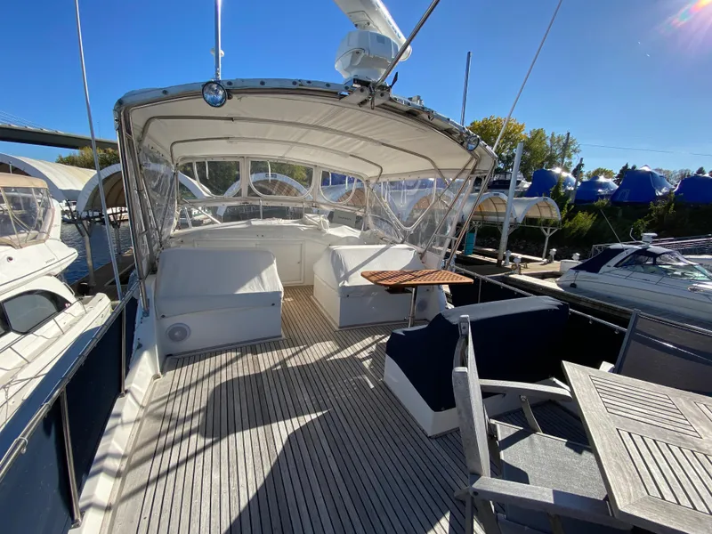 Slide: The Image of 1992 Grand Banks 46 Europa yacht deck with seating and canopy under clear blue sky. - 10