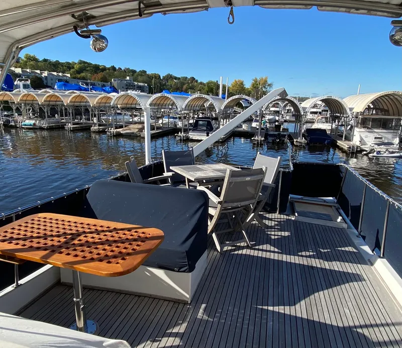 Slide: The Image of Deck view of 1992 Grand Banks 46 Europa yacht at marina with seating and table. - 11