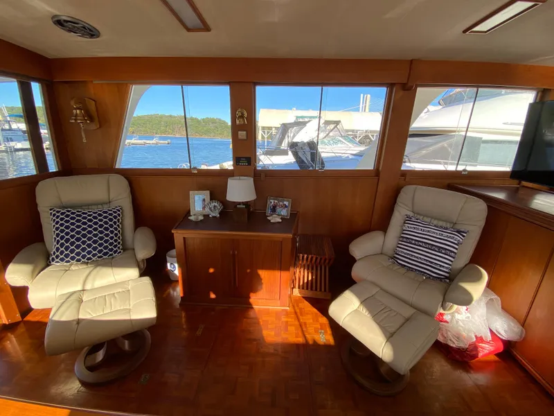 Slide: The Image of Interior of 1992 Grand Banks 46 Europa yacht with two beige chairs and a wooden cabinet. - 23
