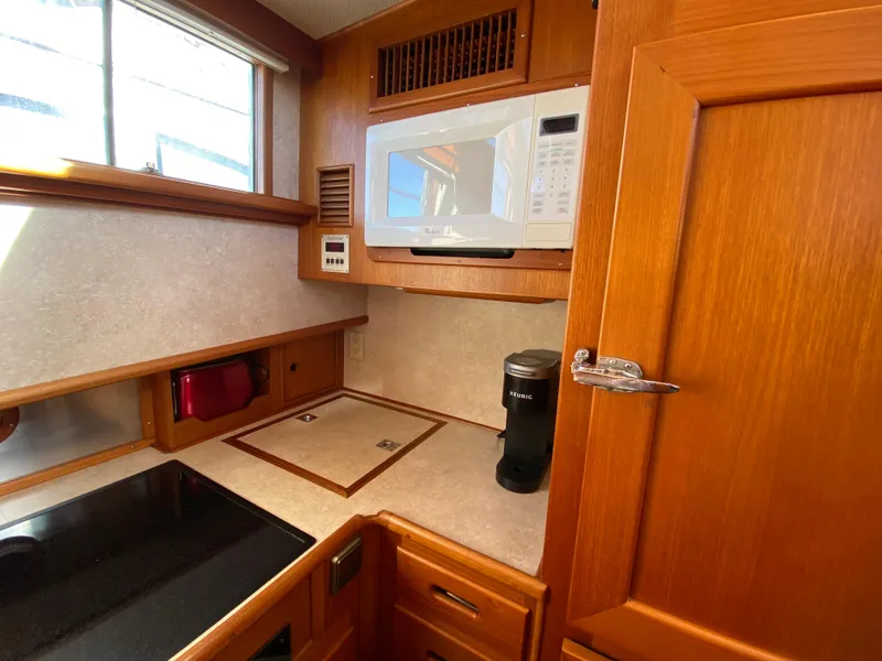 Slide: The Image of 1992 Grand Banks 46 Europa kitchen with microwave, coffee maker, and wooden cabinetry. - 37