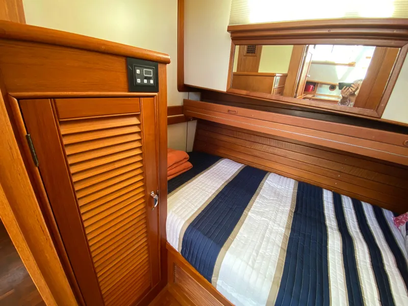 Slide: The Image of Cozy cabin interior of 1992 Grand Banks 46 Europa with wooden finishes and striped bedding. - 42