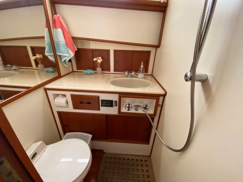 Slide: The Image of Bathroom interior of 1992 Grand Banks 46 Europa yacht, featuring sink, toilet, and showerhead. - 46