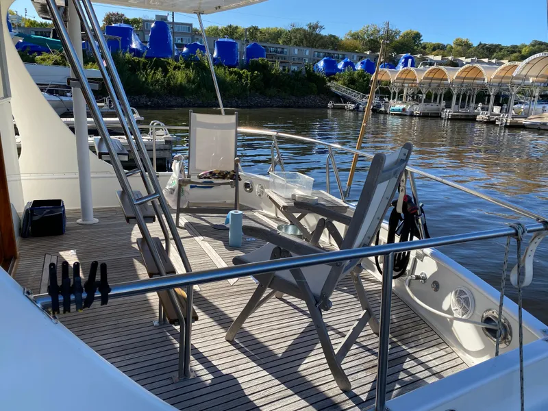 Slide: The Image of Deck of 1992 Grand Banks 46 Europa yacht with chairs and scenic marina view. - 8