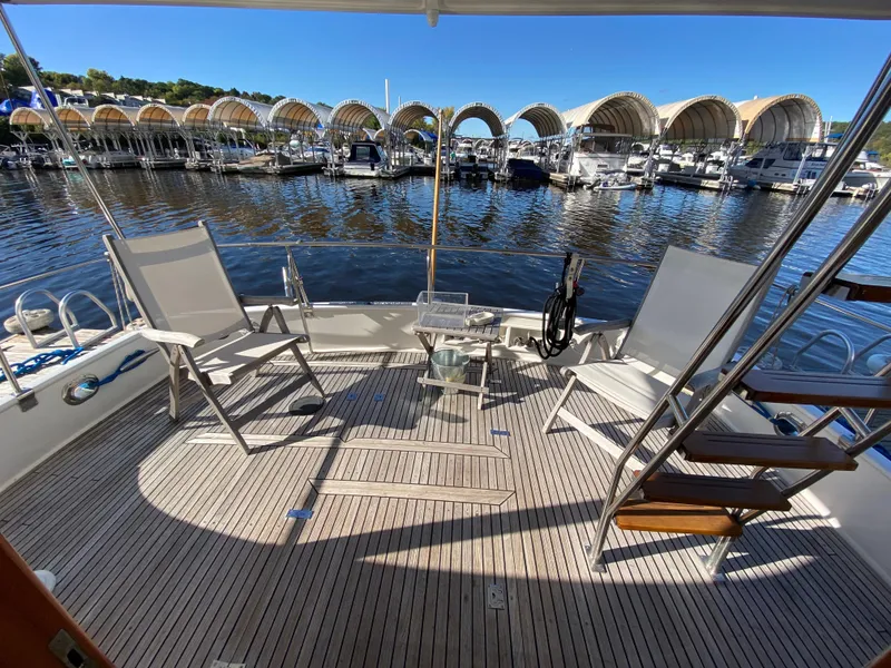 Slide: The Image of Deck of 1992 Grand Banks 46 Europa yacht with chairs and marina view. - 9