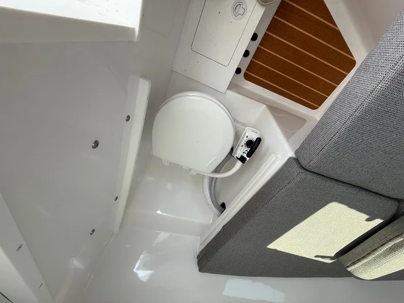 Slide: The Image of Interior of 2026 Steiger Craft 28 Fisherman boat, featuring a compact marine toilet. - 16