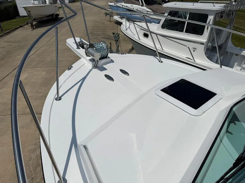 Slide: The Image of 2026 Steiger Craft 28 Fisherman boat deck with railing and hatch, docked outdoors. - 18