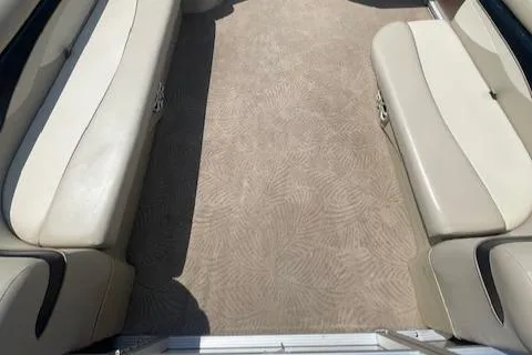 Slide: The Image of 2011 Bennington LSI boat interior with beige seating and patterned carpet. - 11