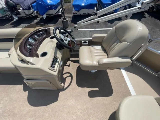 Slide: The Image of Captain's seat and helm of a 2011 Bennington LSI boat, featuring beige upholstery. - 5
